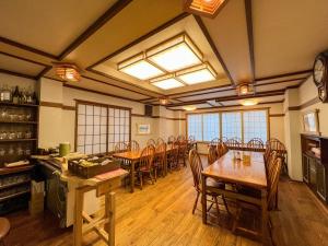 a dining room with wooden tables and chairs at Chouchinya in Nozawa Onsen