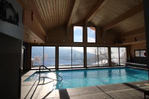 ein großes Hallenbad mit einem großen Fenster in der Unterkunft Chalet Titlis in Bernex + 41 Fotos