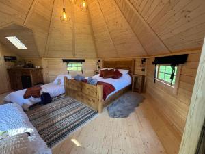 a bedroom with two beds in a wooden house at Press Brook Park in Clay Cross