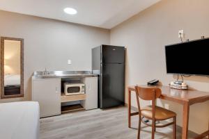 a kitchen with a desk and a refrigerator and a microwave at Suburban Studios near Mesa Verde in Cortez +22 photos
