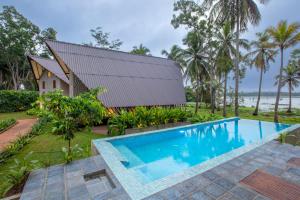 an image of a swimming pool in front of a house at Avora Lake Villas in Anuradhapura