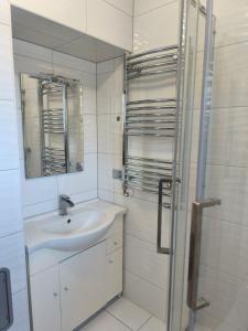 a white bathroom with a sink and a shower at Przystanek Prządki in Czarnorzeki +16 photos