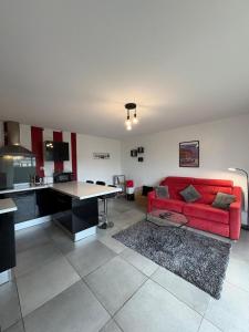 a living room with a red couch and a table at Appartement 200m plage Dinard in Dinard +6 photos