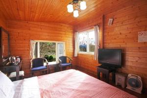 a bedroom with a bed and a flat screen tv at Xiayun in Fuxing