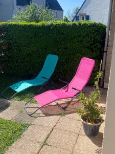 a pink and blue lawn chair sitting next to a hedge at Appartement 200m plage Dinard in Dinard