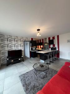 a living room with a red couch and a kitchen at Appartement 200m plage Dinard in Dinard