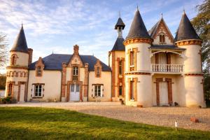 an old castle with turrets on a lawn at Domaine du Riadoux in Bonneuil