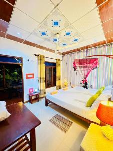 a large bedroom with a large bed and a table at Freedom Cottage & Safari in Tissamaharama