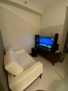 a living room with a white couch and a flat screen tv at AHN Haven in Sampong