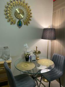 a dining room with a glass table and a clock on the wall at AHN Haven in Sampong