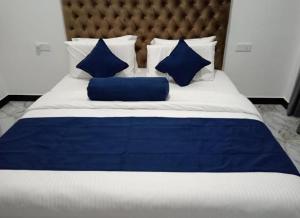 a blue and white bed with blue pillows on it at Breeze Climes Ella in Ella