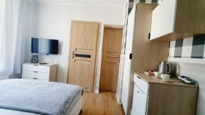a small room with a bed and a television at Willa Azur blisko plaży, centrum Mielna in Mielno