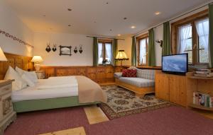 a bedroom with a bed and a couch and a television at Villa Salis in Altaussee