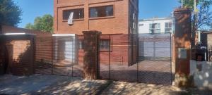 a metal fence in front of a brick building at Casa Edina in Encarnación