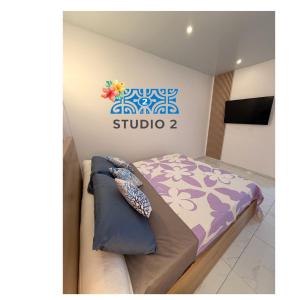 a bed in a room with a sign on the wall at Kahaia stay lodge in Papeete