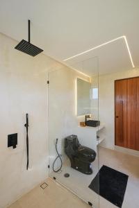 a bathroom with a glass shower with a toilet at Nyaman lima Villas in Canggu