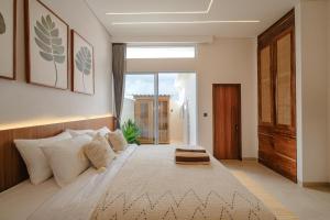 a bedroom with a large bed with a large window at Nyaman lima Villas in Canggu +9 photos