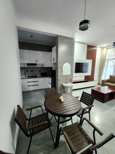 a living room with a table and chairs and a kitchen at Karibu Haven Apartments in Arusha