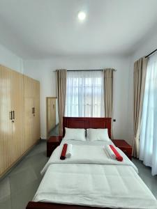 a bedroom with a large bed with red pillows on it at Karibu Haven Apartments in Arusha