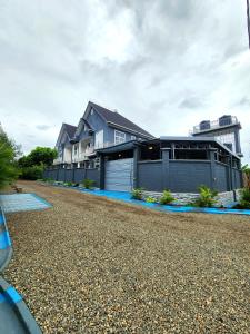 a large house with a gravel driveway at Karibu Haven Apartments in Arusha