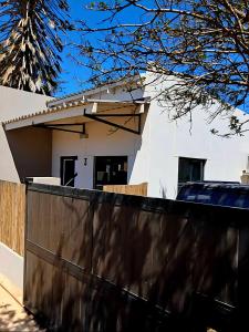a white house with a fence in front of it at Shiloah Guesthouse Unit 3 in Oranjemund +12 photos