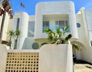 a white house with palm trees in front of it at Villa Lipa in Ungasan