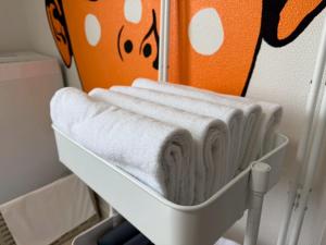 a white towel rack with four towels on it at mkh room TAKAMATSU in Takamatsu