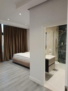 a bedroom with a bed and a bathroom with a sink at Rezidenca Pahumi 2 in Durrës +32 photos