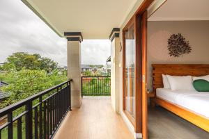 a bedroom with a bed on a balcony at Cove Ayuna in Canggu
