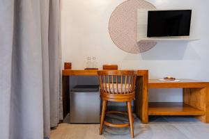 a wooden desk with a chair and a television at Cove Ayuna in Canggu