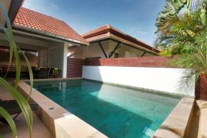 a swimming pool in front of a house at Malee Beach C6 in Phra Ae beach