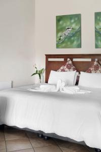 a bed with white sheets and pillows on it at Ardmore Guest Farm in Champagne Valley +70 photos