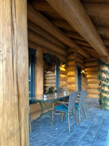 a patio with a table and chairs on a porch at Sparrow's Nest Spacious Mountain Chalet with Hot Tub and Panoramic Views in Râşnov