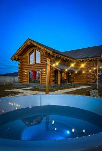 a log cabin with a pool in front of it at Sparrow's Nest Spacious Mountain Chalet with Hot Tub and Panoramic Views in Râşnov