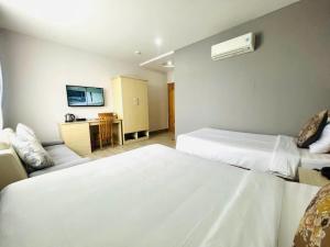 a hotel room with two beds and a couch at Hotel Hoài Bảo in Ấp Rạch Mẹo