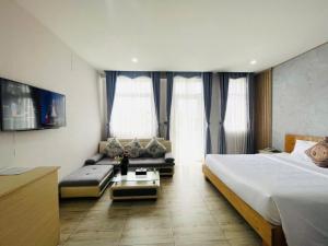 a hotel room with a bed and a couch at Hotel Hoài Bảo in Ấp Rạch Mẹo