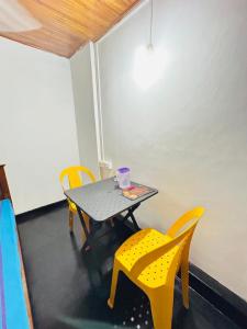 a table and chairs with a cup on top of it at evol Hotel Battaramulla in Battaramulla