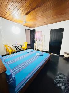 a large bed in a room with a table and chairs at evol Hotel Battaramulla in Battaramulla