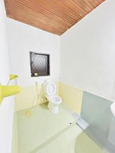 a bathroom with a toilet and a window at evol Hotel Battaramulla in Battaramulla
