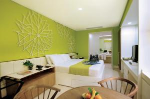 a room with a bed and a table and a television at Astoria Boracay in Boracay