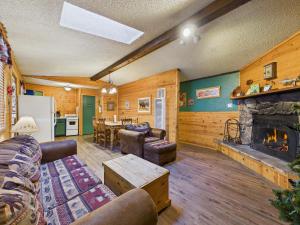 a living room with a fireplace and a table at Whispering Pine Cabins in Ruidoso