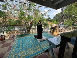 a woman sitting on a yoga mat on a balcony at Hostel Honsa in Cochin