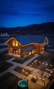 a wooden building with lights in a parking lot at night at Sparrow's Nest Spacious Mountain Chalet with Hot Tub and Panoramic Views in Râşnov