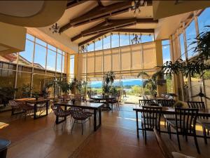 a restaurant with tables and chairs in a room with large windows at Palawan Coliving - Palawan Coworking in Puerto Princesa City
