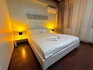 a bedroom with a white bed with towels on it at Sibiutiful - Ultracentral in Sibiu