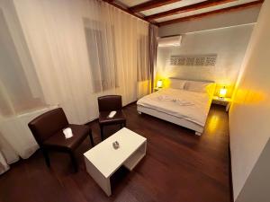 a bedroom with a bed and a table and chairs at Sibiutiful - Ultracentral in Sibiu