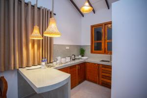 a kitchen with two lights hanging from the ceiling at The Clouds Ahangama in Ahangama +52 photos