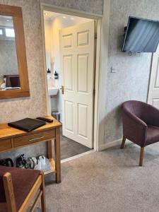 a room with a door and a chair and a table at The Dog & Partridge Country Inn in Ashbourne