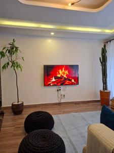 a living room with a fire on the wall at Pearl Apartment Ruaka in Ruaka