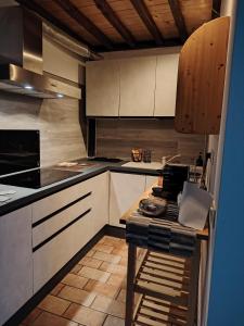 a kitchen with white cabinets and a table in it at Bugnolo Miniloft in Poggibonsi